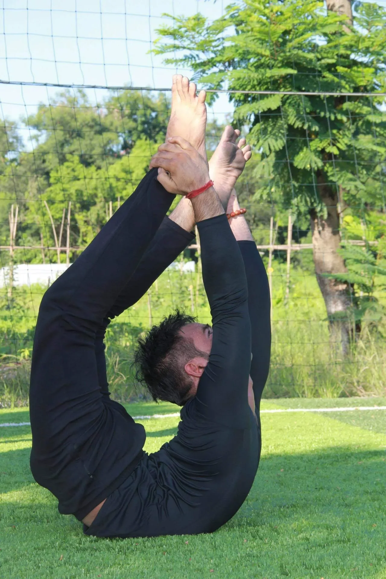Master Anil demonstrating an advanced inverted asana outdoors